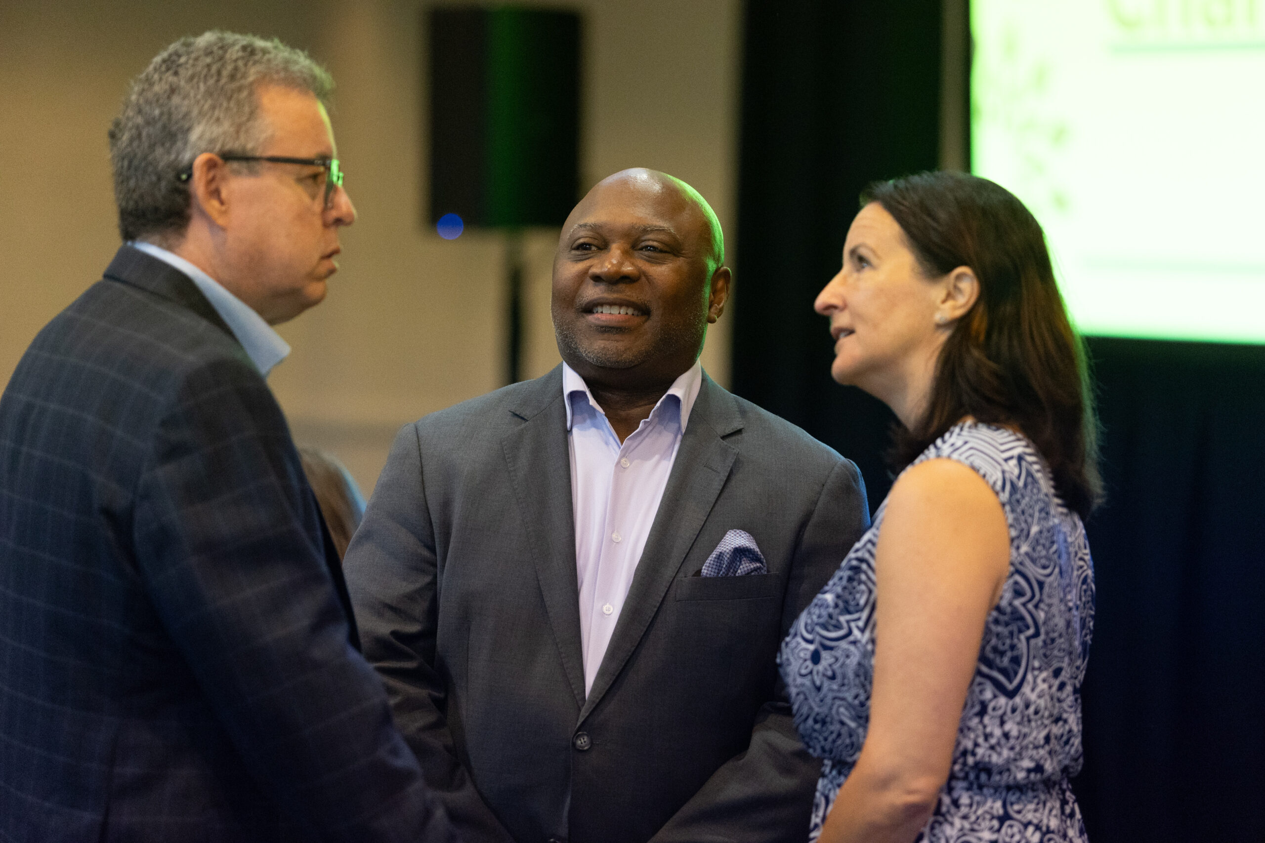Three individuals standing and talking